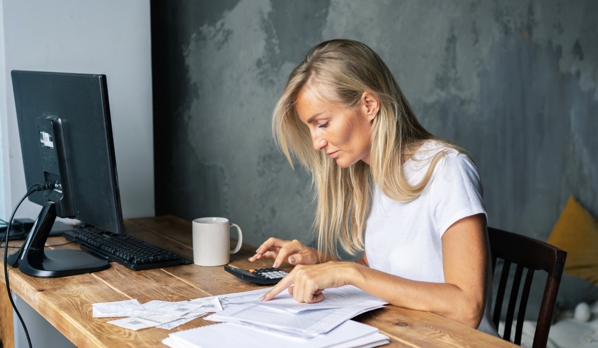 Mujer revisando facturas en su escritorio.