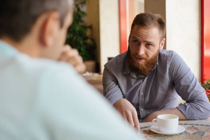 bărbatul vorbește cu partenerul de recomandare în timpul conversației cu cafeaua din cauza bugetului mic de marketing