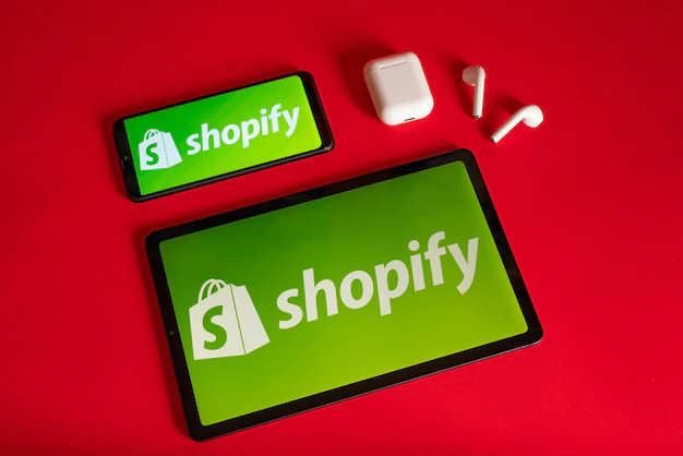 Foto tokio japan 05 de junho de 2022 shopify página da web exibida em um smartphone laptop moderno e notebook em fundo vermelho logotipo shopify no iphone