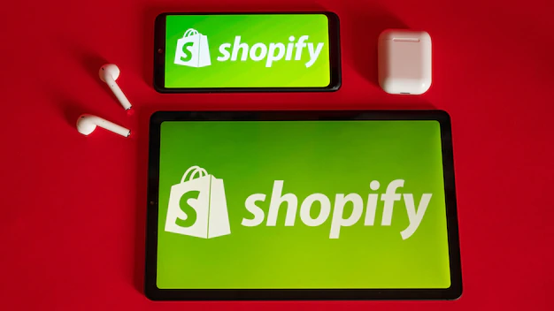 写真 tokio japan 2022年6月5日 赤い背景の最新のラップトップスマートフォンとノートブックに表示されたshopify Webページ iPhoneのshopifyロゴ