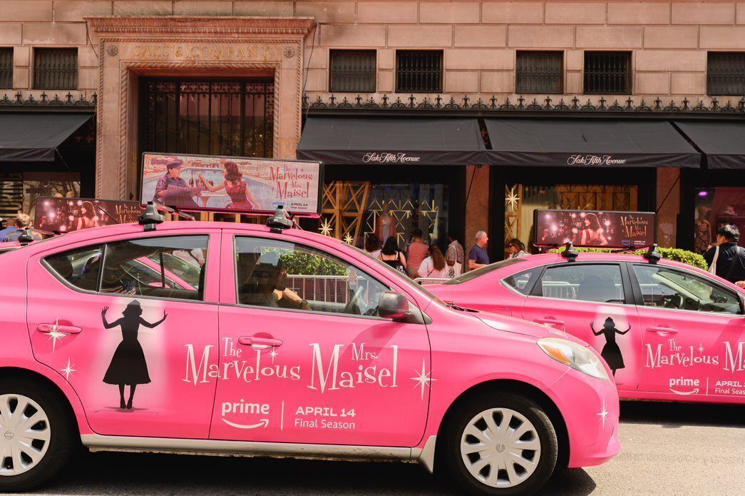 Dois táxis rosa com a marca estacionam do lado de fora da Saks Fifth Avenue, em Nova York, como parte de um esforço da Amazon Prime Video para promover sua série "The Marvelous Mrs. Maisel".