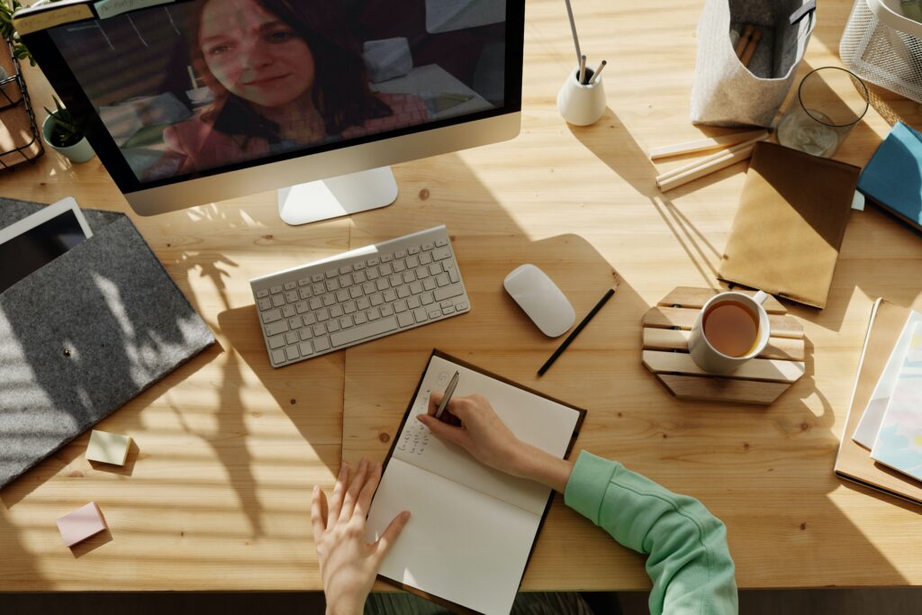 Alguém fazendo anotações enquanto participa de um treinamento on-line.