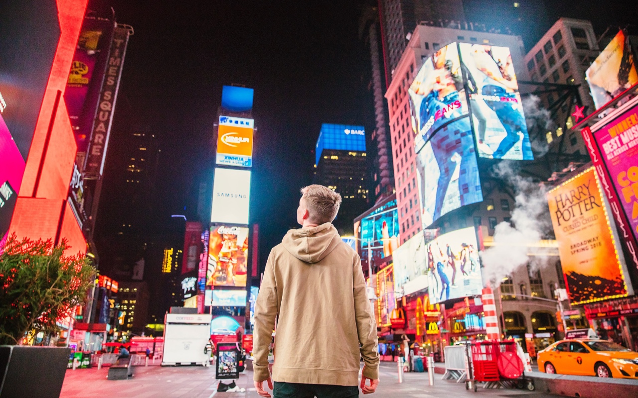 Un uomo che guarda gli annunci pubblicitari in un incrocio