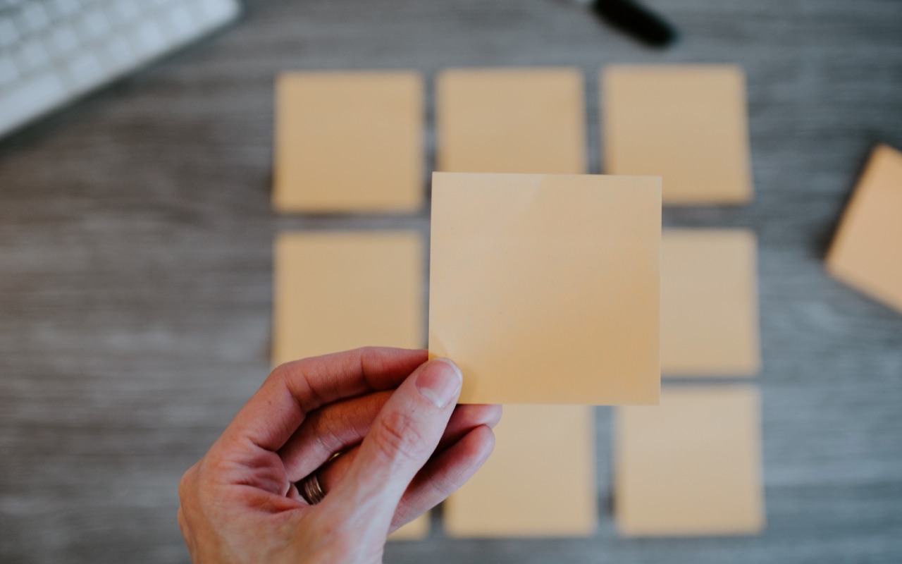 Una mujer sosteniendo una nota post-it vacía