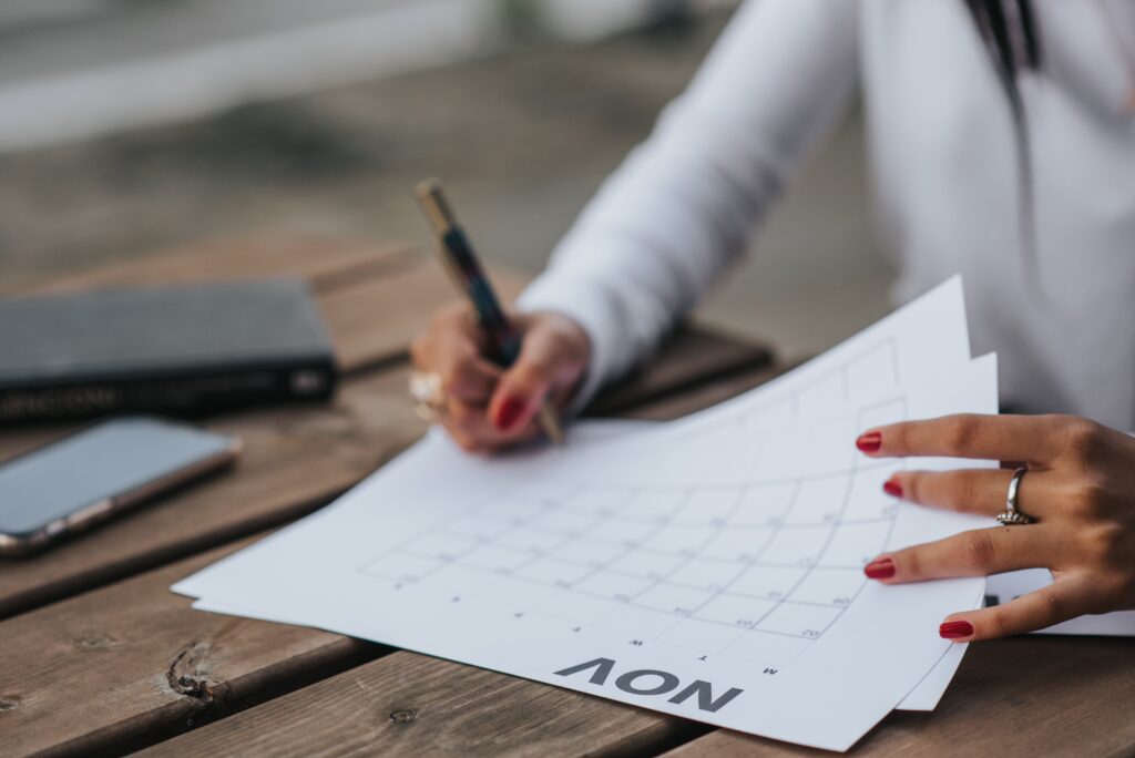 Uma mulher escrevendo em um calendário