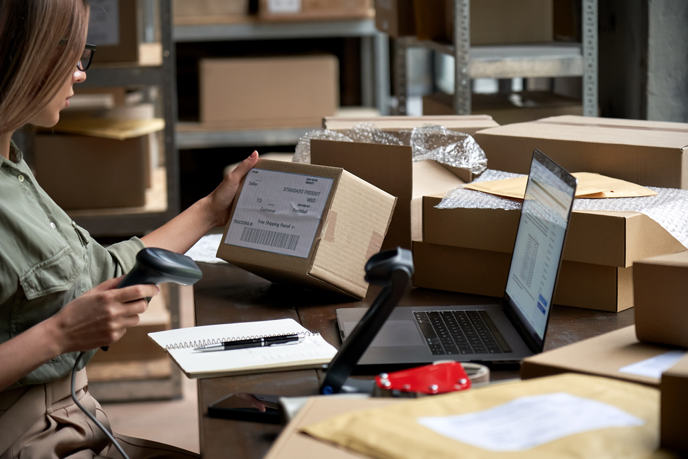 femme scannant des colis amazon à son bureau