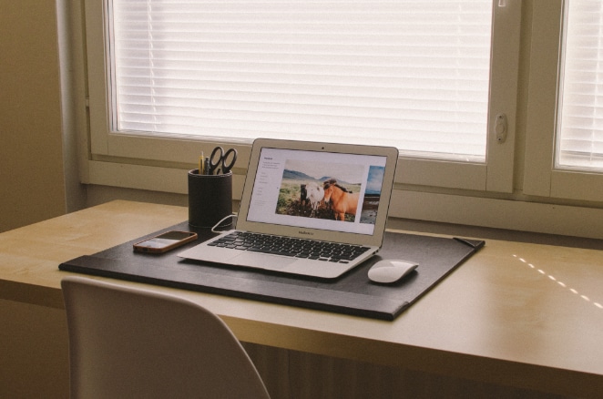 ein ordentlicher Schreibtisch mit Utensilienhalter, Telefon, Laptop und Maus