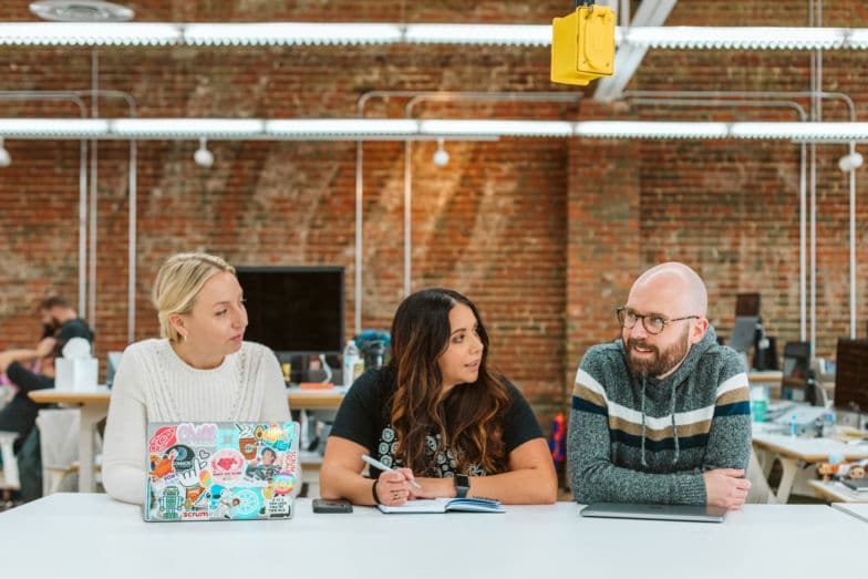 Un gruppo di tre persone coerenti che lavorano sulla loro strategia di eCommerce SEO.