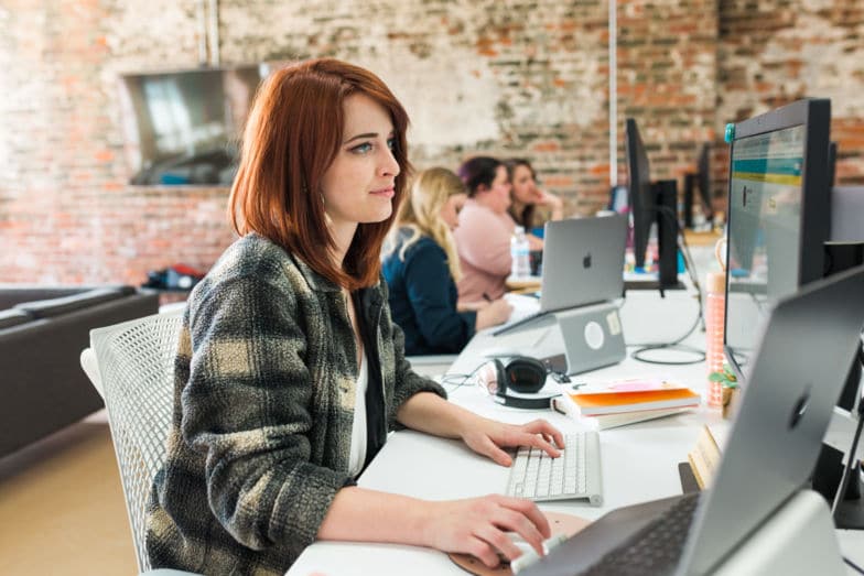 Une femme travaillant à son bureau pour personnaliser les permaliens WordPress.