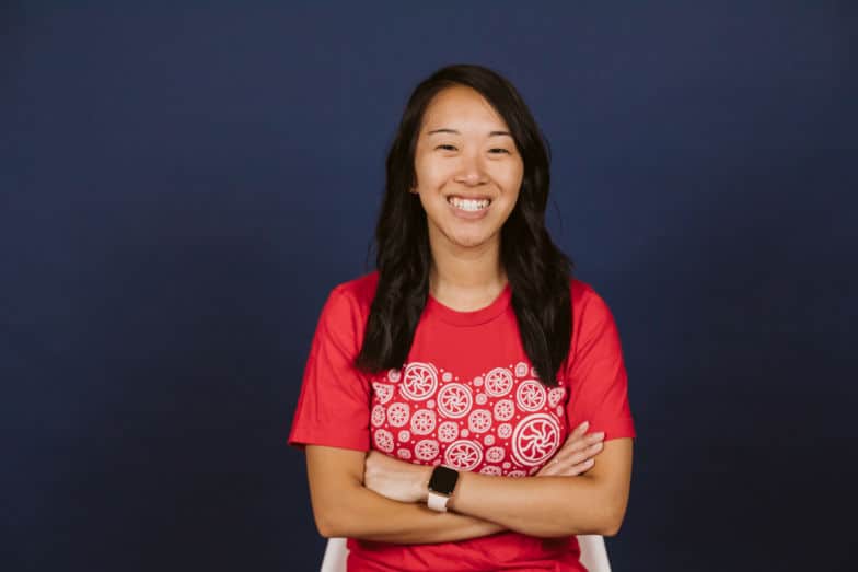 una mujer con una camisa roja Flywheel sonríe directamente a la cámara