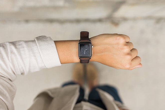 femme regardant apple watch avec horloge affichée vérifiant son emploi du temps